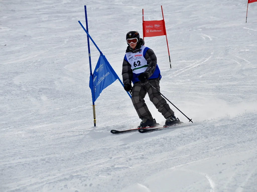 Snowboarder mit Startnummer 63 fährt durch das Tor.